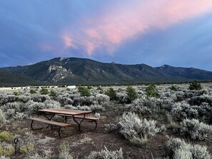 Une table de pique-nique dans un paysage désertique, avec des montagnes en arrière-plan.