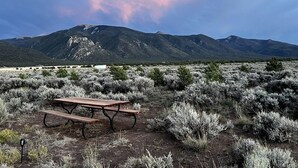 Een picknicktafel in een woestijnlandschap, met bergen op de achtergrond.