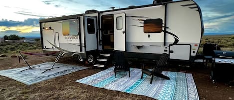 Un vehículo recreativo con cocina, mesa de comedor y parrilla.