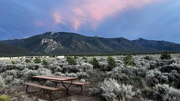 A picnic table in a desert landscape with mountains in the background.