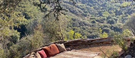 Un espace extérieur aménagé dans un style rustique, offrant une vue sur un paysage montagneux.