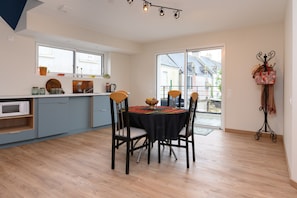 Una cocina moderna con comedor, ventanas amplias y vistas al exterior.