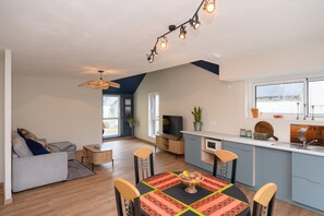 Un espacio habitable moderno con comedor, cocina y zona de estar.