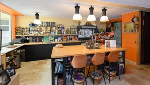 Une cuisine dotée d’un îlot central en bois, de luminaires suspendus et d’une variété d’ustensiles de cuisine et d’objets de décoration.