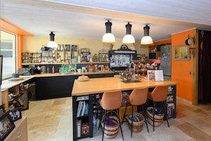 Una cocina con isla de madera, luces colgantes y diversos utensilios de cocina y adornos.