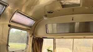 Ein gemütlicher Innenraum mit einer Couch, einem Fenster und einem Tisch.