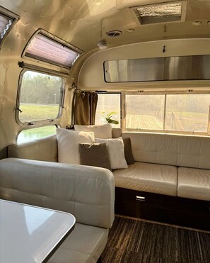 Un interior acogedor con un sofá, una ventana y una mesa.