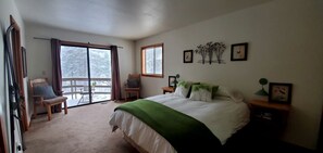 Une chambre à coucher avec un lit, une chaise, une fenêtre et un balcon.