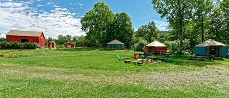 A rural property with a barn, yurts, and a picnic area.