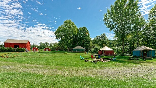 Una propiedad rural con granero, yurtas y zona de picnic.