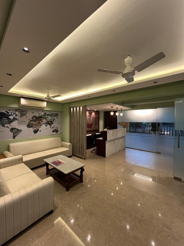 A modern living room with a sofa, coffee table, and a world map on the wall.
