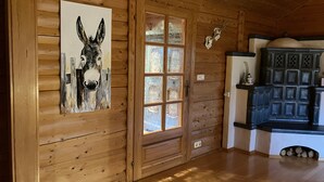 Un interior de madera con una puerta de madera, un ventanal de cristal y un armario con detalles decorativos.