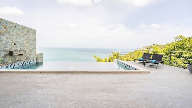 A rooftop infinity pool with a stone wall and two lounge chairs with blue towels. - Astoria Villa #2 – 3 Bed Pool Villa in Koh Samui (Chang Wat Surat Thani)