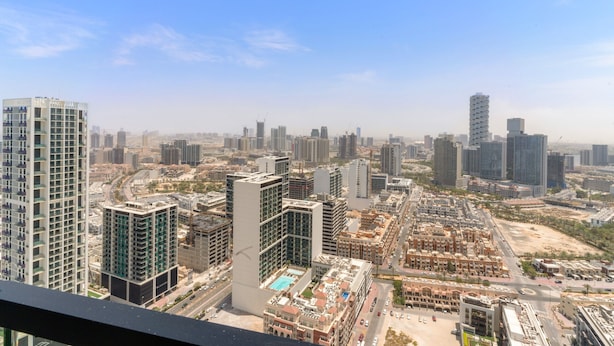 A high-rise building with multiple floors, surrounded by other tall buildings in a cityscape. - Binghatti Onyx - 3112 2BD (Dubai)