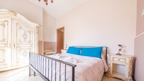 A bedroom with a bed, a nightstand, a wardrobe, and a door leading to another room. - Apartment 'La Casa Dei Limoni' with Mountain View and Private Terrace (Gaggi)