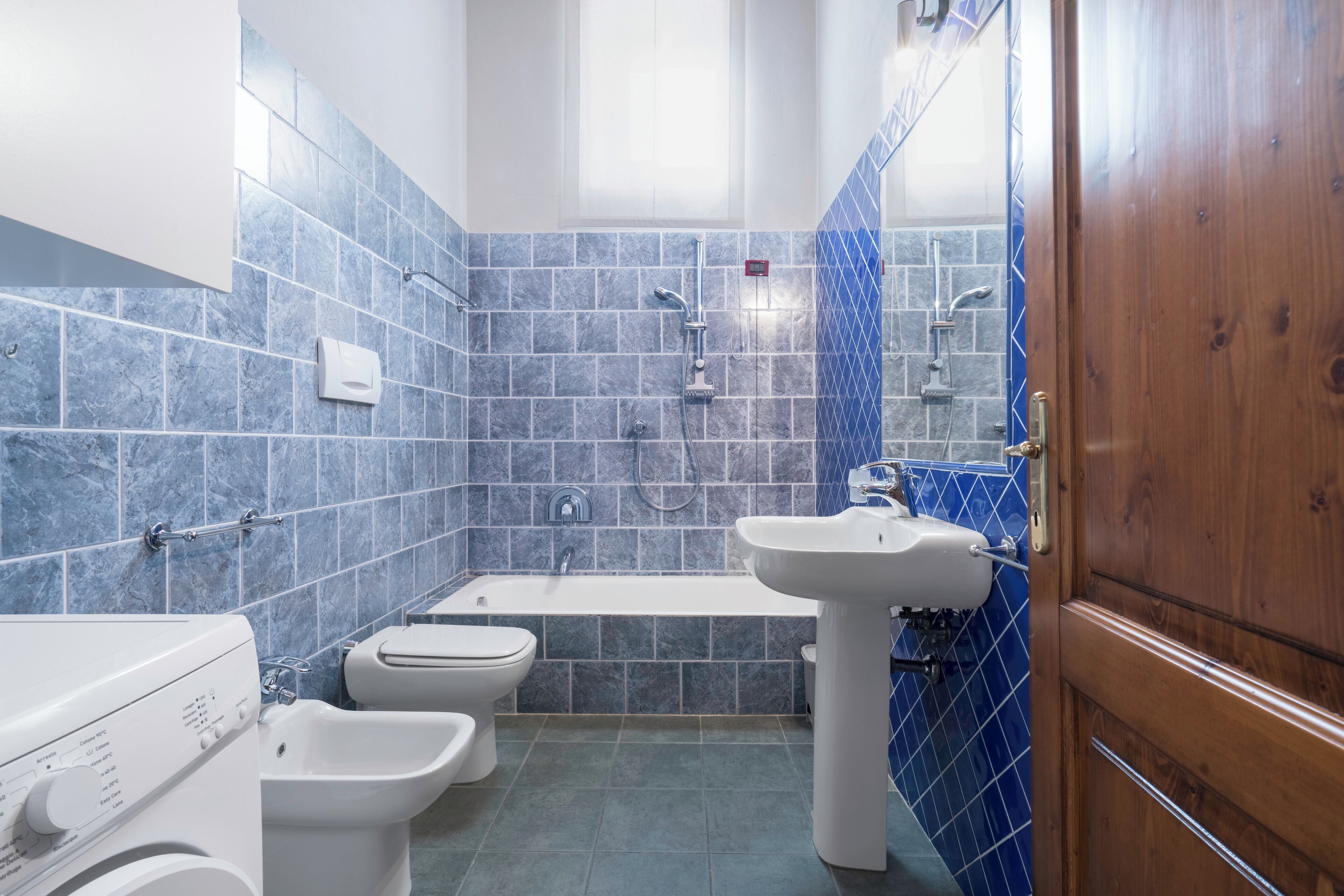 Une salle de bain avec une baignoire, un lavabo et deux bidet.