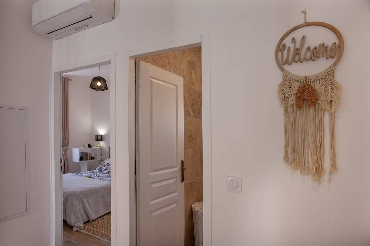 A hallway with a bed, a door, and a welcome sign.