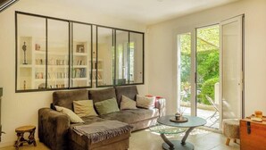 A living room with a sofa, a glass coffee table, and a bookshelf. - Casa Murati (Sisco)
