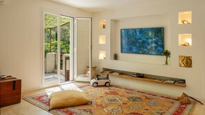 A modern living room with a large window, a colorful rug, a toy car, and a painting on the wall. - Casa Murati (Sisco)