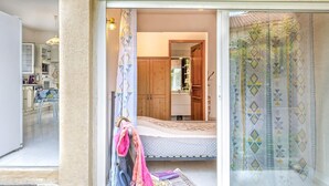 Un dormitorio con cama, armario y baño visible a través de una puerta abierta.