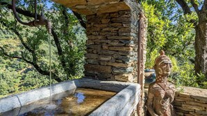 A stone structure with a water feature and a statue. - Casa Di A Scala (Brando)