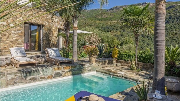 A stone villa with a swimming pool, lounge chairs, and a view of the surrounding hills. - Casa Di A Scala (Brando)