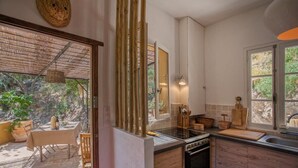 A kitchen with wooden cabinets, a stove, and a dining area with a table and chairs.