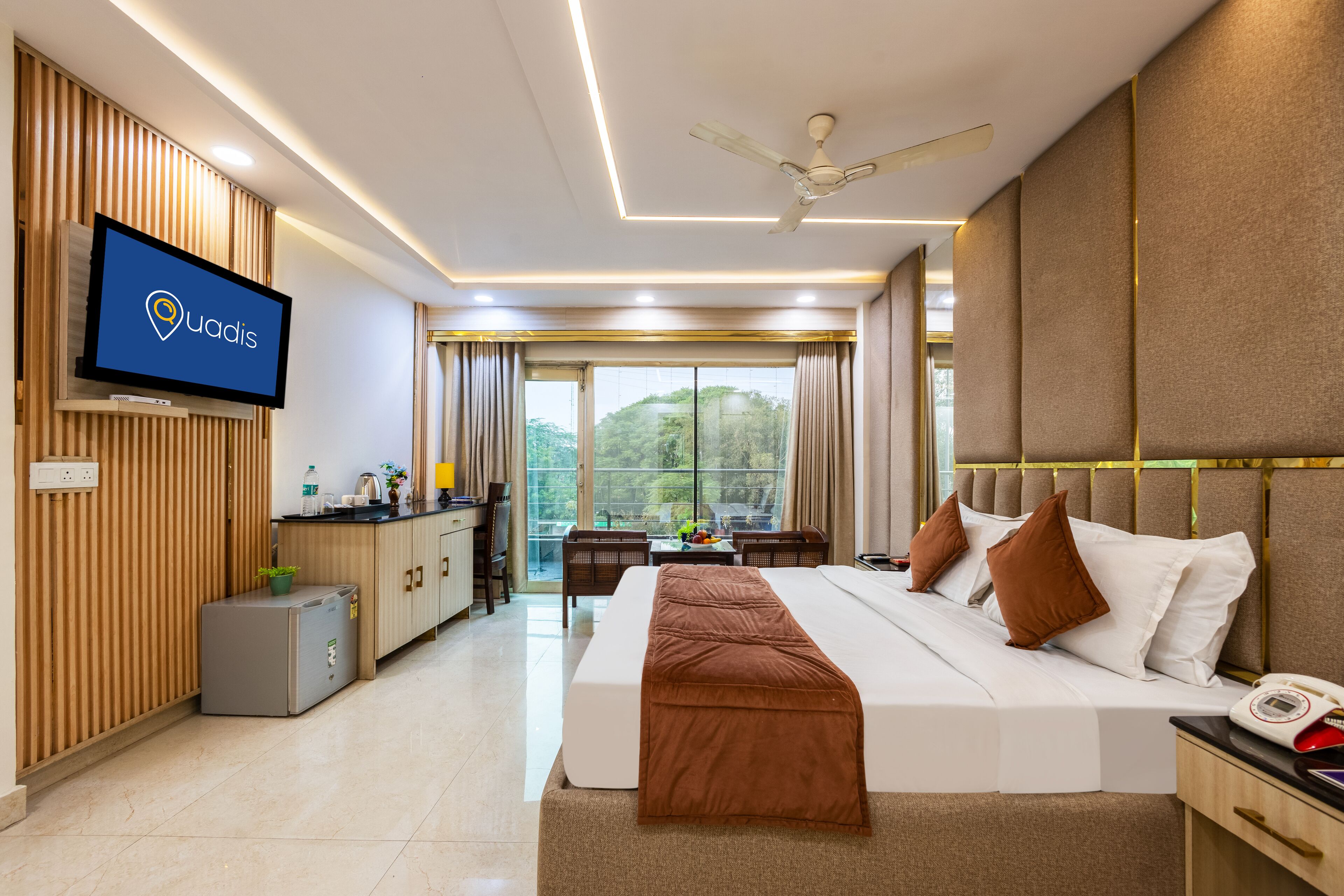 A modern hotel room with a bed, a desk, a television, and a view of the outdoors.