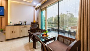 A modern kitchen with a dining area, large windows, and a flat-screen TV.