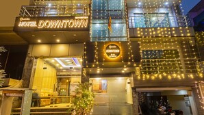 A hotel with a modern facade, multiple floors, and a well-lit entrance.