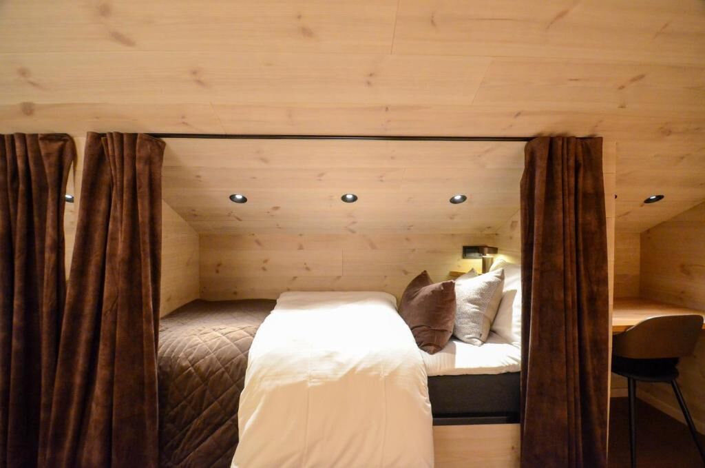 A small, cozy bedroom with a single bed, a nightstand, and a chair.