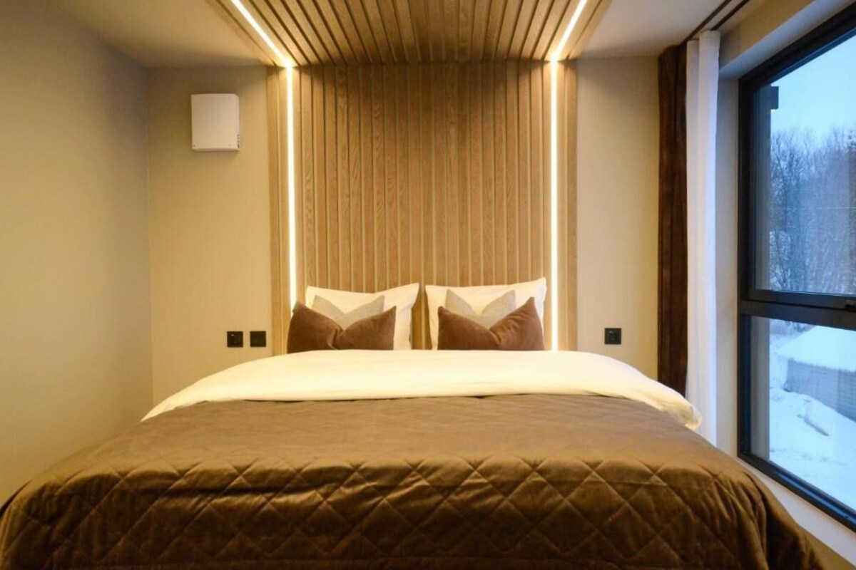Ein Hotelzimmer mit einem Bett, einem Fenster und einer Wandleuchte.