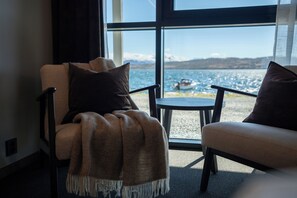 A room with a large window, two chairs, a small table, and a blanket. - Steam Pier Adventure Hotel (Tromsø)