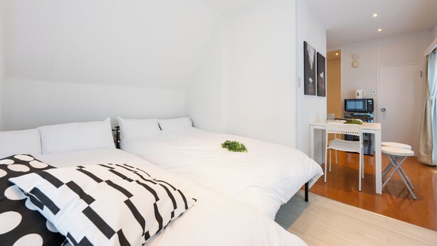 Una habitación de hotel moderna con una cama grande, un escritorio con una silla, un televisor y una mesita.