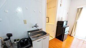 Una cocina compacta con fregadero, cocina y microondas.