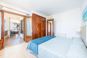 Una camera da letto con un letto, un armadio in legno e vista sull'esterno.