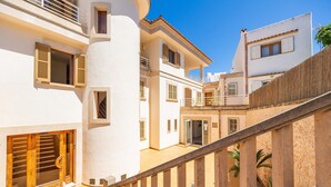 A multi-story building with balconies, a staircase, and a courtyard.