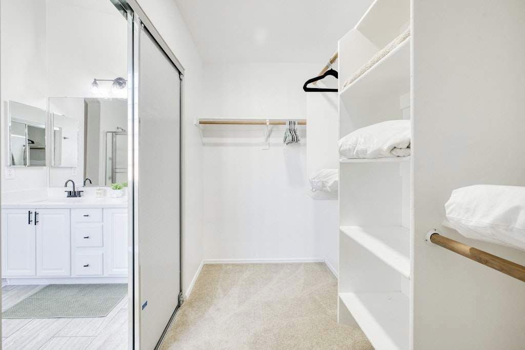 Un bagno moderno con doccia, servizi igienici e lavandino. È presente un portascopevoli con un asciugamano appeso.