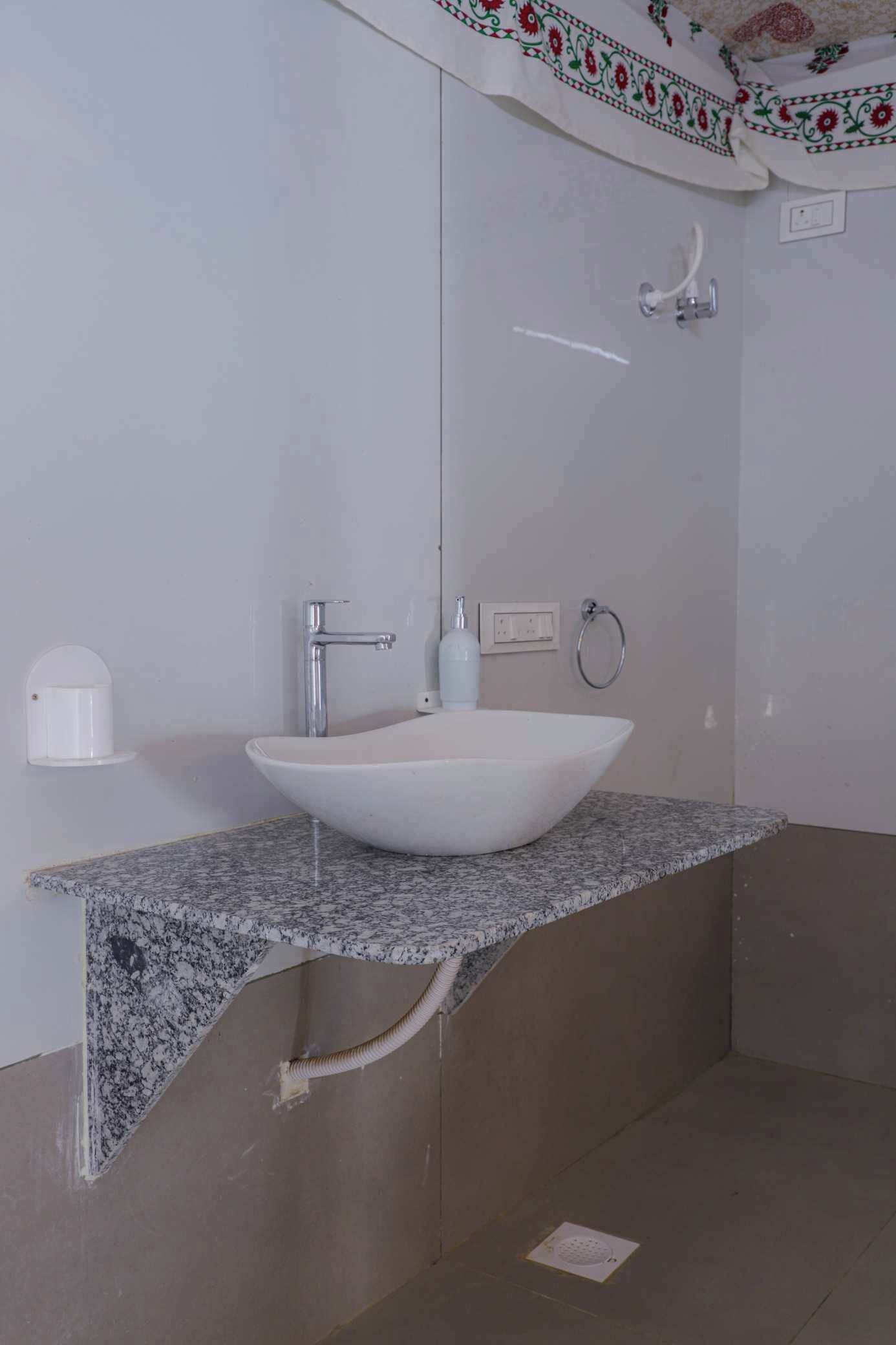 A bathroom with a white sink, a mirror, and a towel ring.