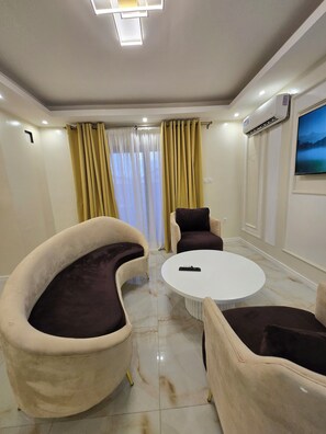 Suite Deluxe, balcón, vista al patio | Área de sala de estar