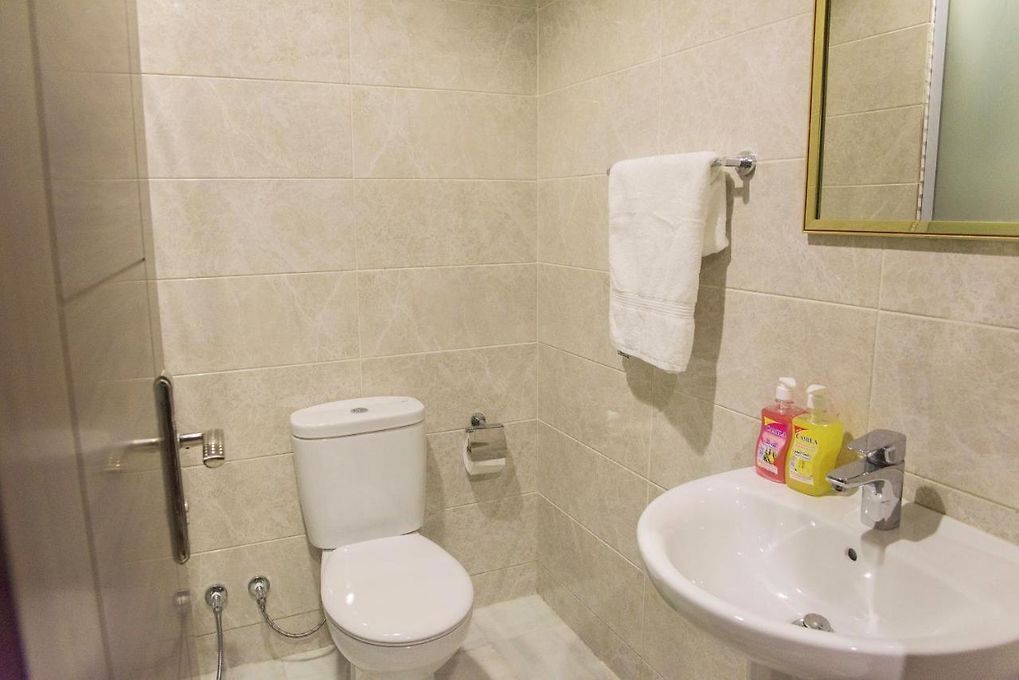 Une salle de bain avec des toilettes, un lavabo et un miroir.