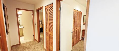 A hallway with wooden doors and a carpeted floor.