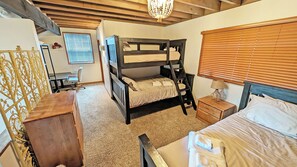 A bunk bed room with a desk, chair, and a small bedside table with a lamp. - Meadow House 42 - Private Hot Tub, A/C, Common Area/Golf Course View (Sunriver)