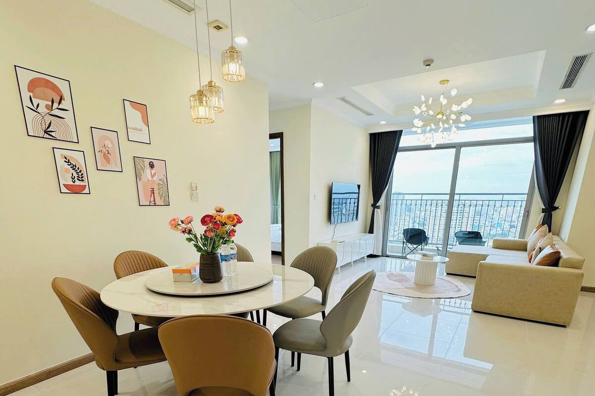 A modern living room with a dining area, large windows, and a balcony.