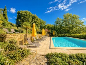 A swimming pool with lounge chairs and yellow umbrellas, surrounded by stone walls and greenery. - La Grange 4/5 personnes (Montoillot)
