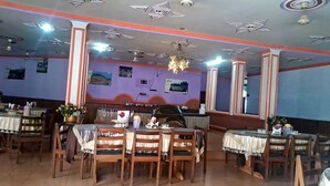 Un restaurante con varias mesas y sillas, decorado con flores y manteles.