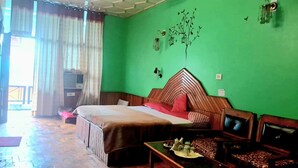 Una habitación con una cama, un escritorio y un televisor.