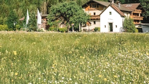 Een bergdorp met traditionele houten huizen, een kerk en een helder uitzicht op een bebost gebergte.