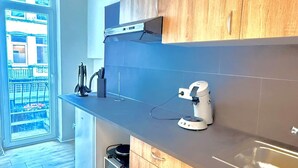 Ett modernt kök med träskåp, en inbyggd ugn och en kaffemaskin.