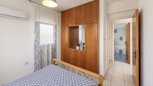 Ein Schlafzimmer mit einem Bett, einem Holzschrank und einem Spiegel.